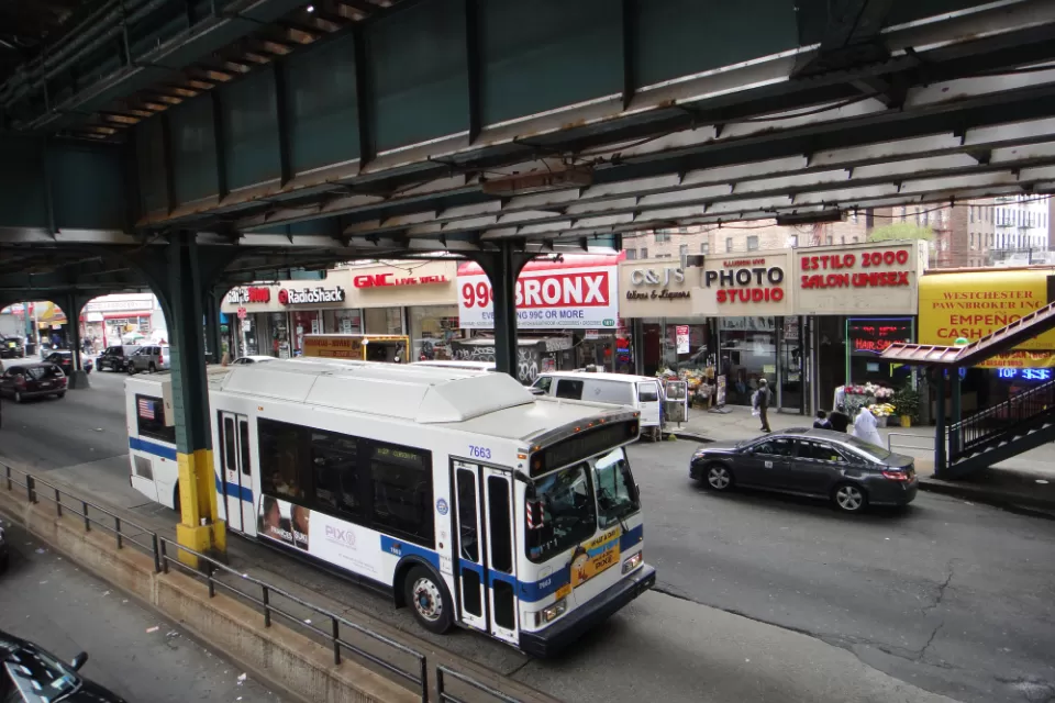 A New York MTA drives down the straight under elevated train tracks in the Bronx in New York City